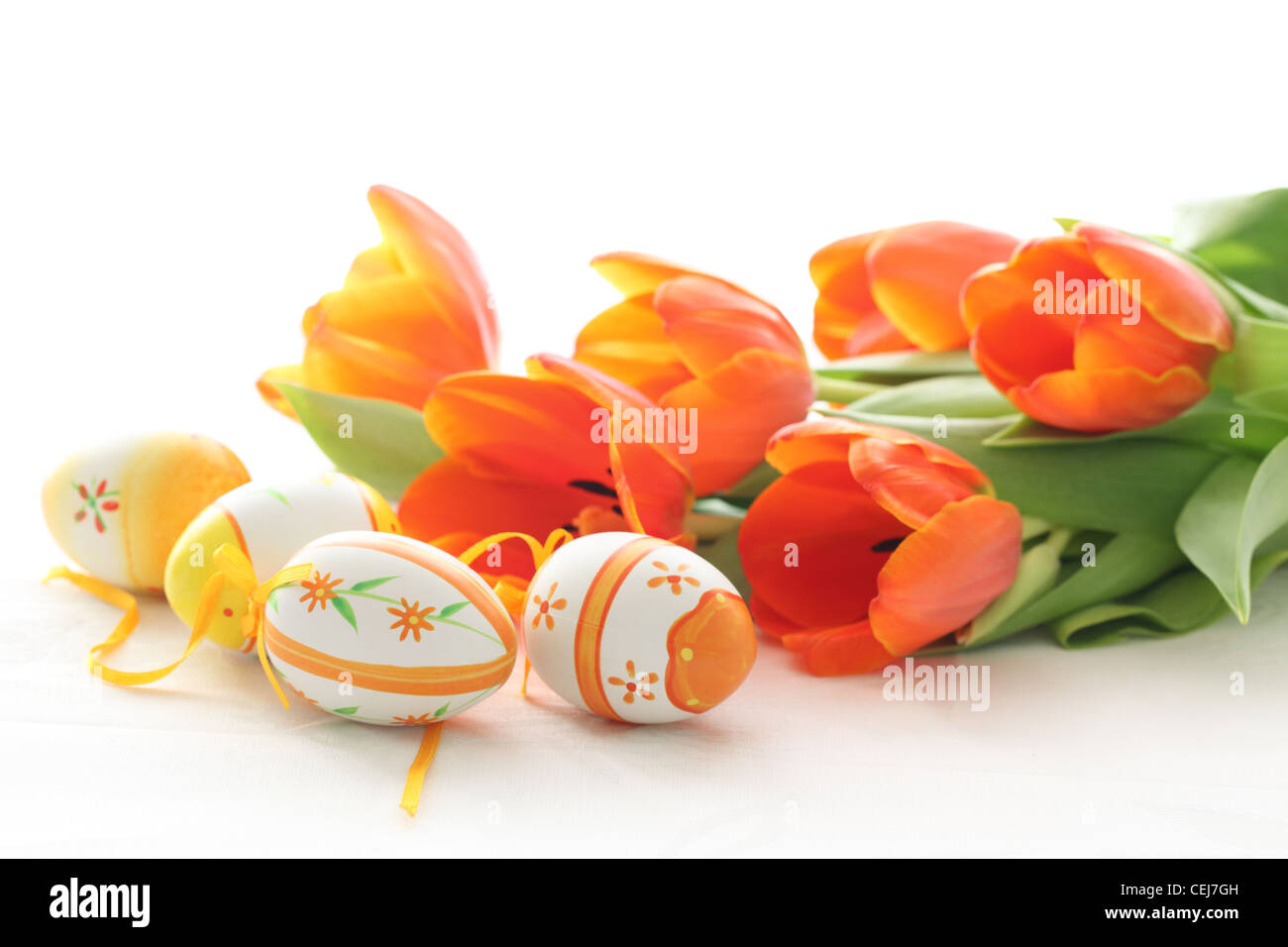 Les oeufs de Pâques avec des tulipes orange isolé sur fond blanc Banque D'Images