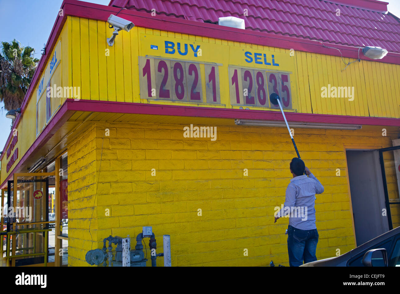 San Ysidro, en Californie - un travailleur change le taux de change affiché dans un magasin près de la frontière entre les États-Unis et le Mexique. Banque D'Images San Ysidro, en Californie - un travailleur change le taux de change affiché dans un magasin près de la frontière entre les États-Unis et le Mexique. Banque D'Images