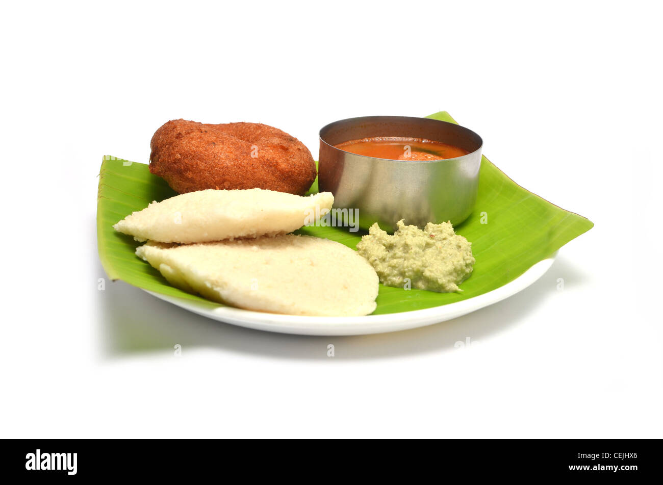 Idli sambhar vada, et chutney, plat indien du sud servi sur des feuilles de banane, isolé sur fond blanc Banque D'Images