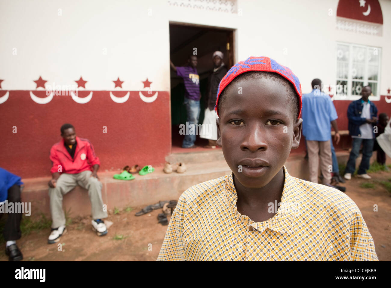 Un garçon se tient devant une mosquée dans la région de Amuria, Ouganda, Afrique de l'Est. Banque D'Images