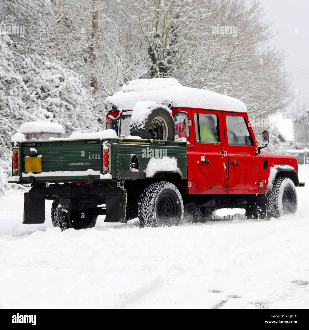 Neige scène Land Rover Defender 130 4x4 de la conduite sur route de campagne étroite route en neige en hiver par temps froid Brentwood Essex England UK Banque D'Images