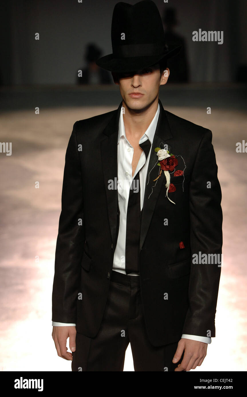 Van Asche Prêt à Porter Paris de vêtements d'un W modèle masculin vêtu d'un costume noir, blanc et rouge des roses blanches épinglées Banque D'Images