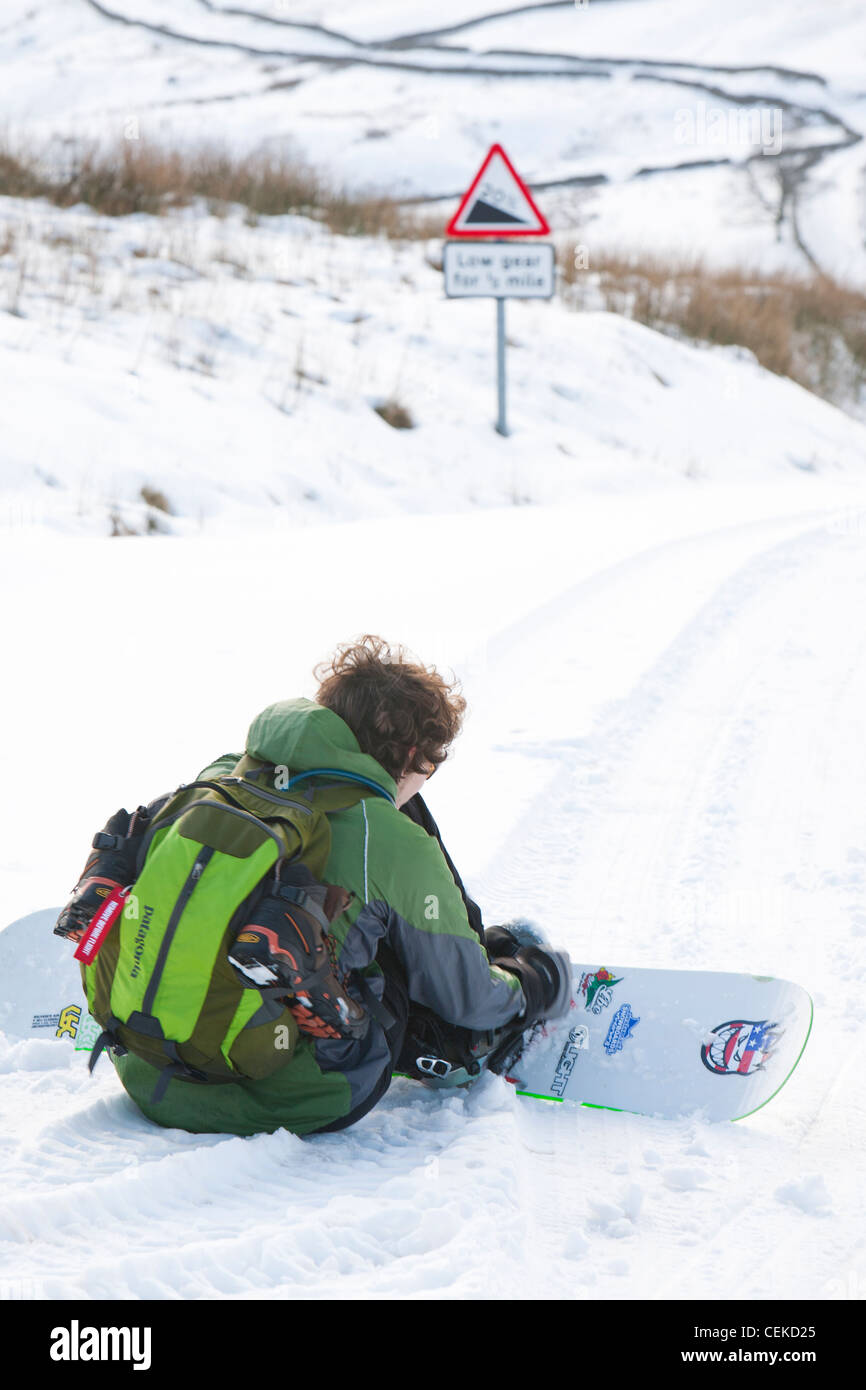 Un homme d'embarquement de la neige vers le bas depuis le sommet de la puce dans le Lake District, UK Banque D'Images