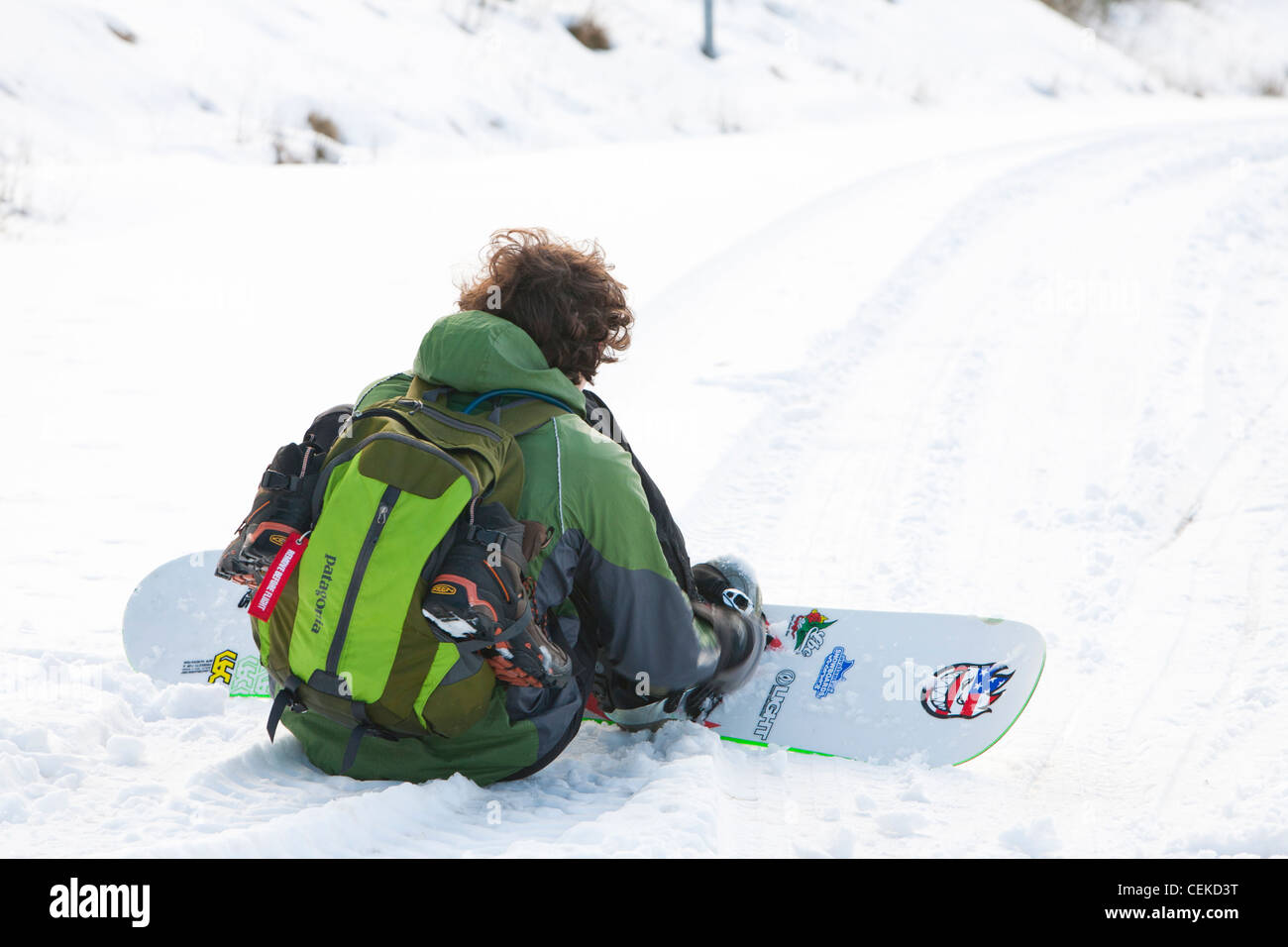 Un homme d'embarquement de la neige vers le bas depuis le sommet de la puce dans le Lake District, UK Banque D'Images