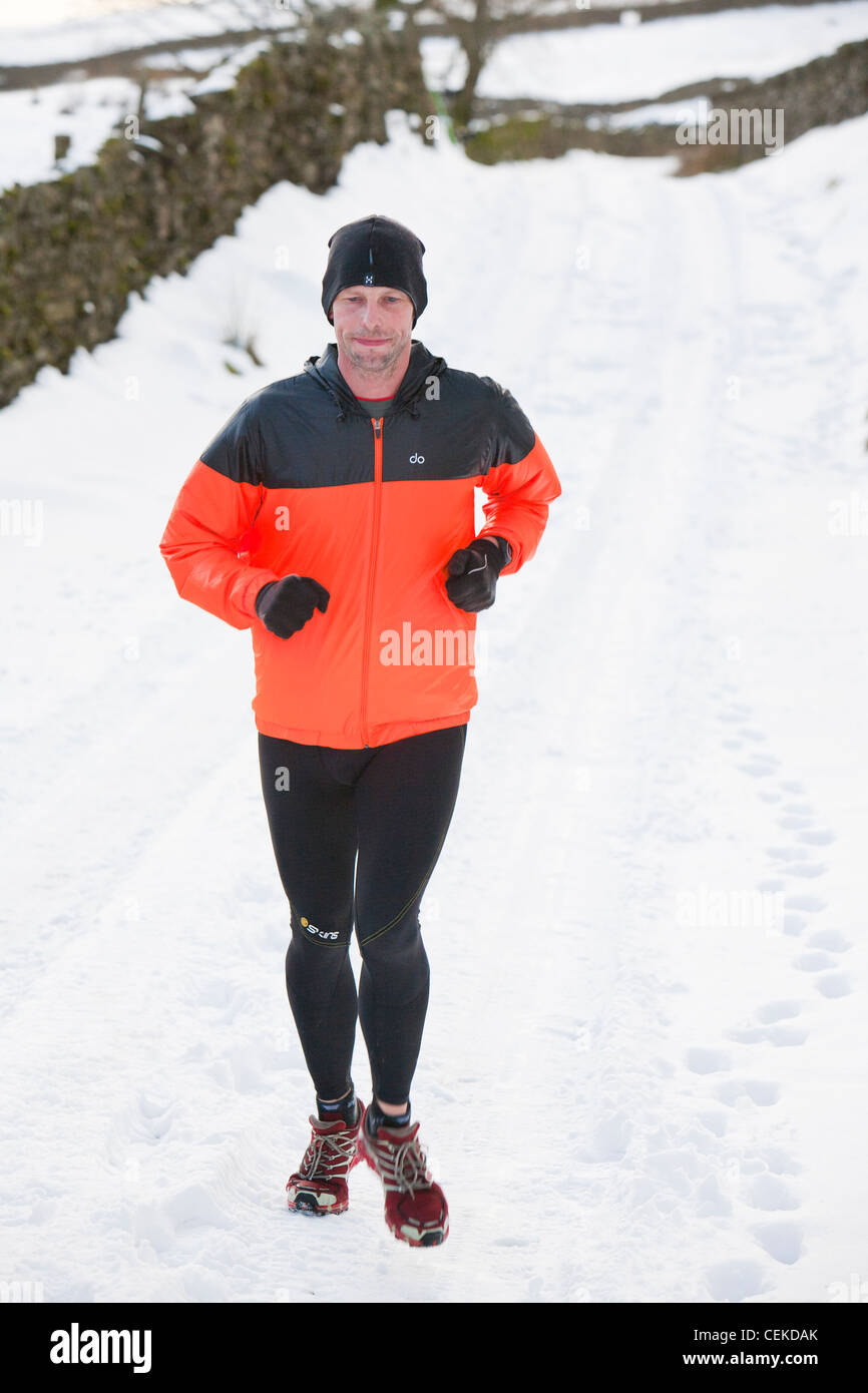 Un homme est tombé en marche jusqu'au-dessus de la Puce Ambleside dans le district du lac en hiver la neige. Banque D'Images
