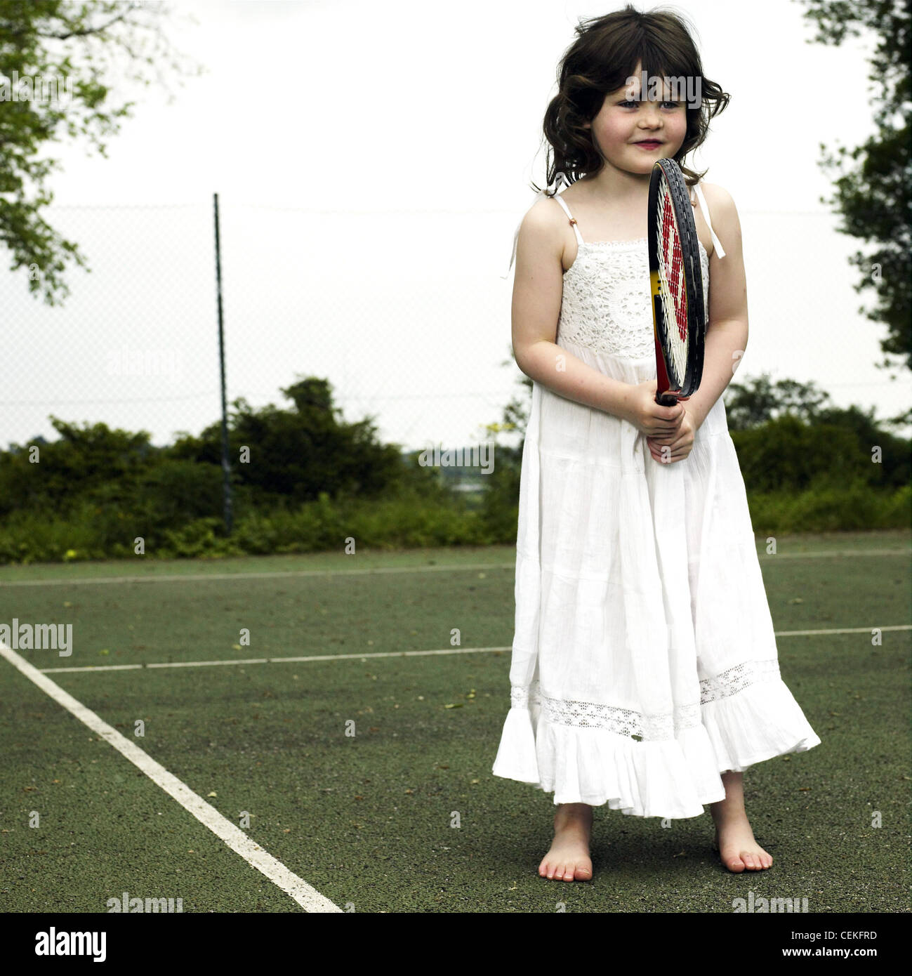 Femme longue robe blanche enfant portant sur l'article de tennis raquette  de tennis holding Photo Stock - Alamy