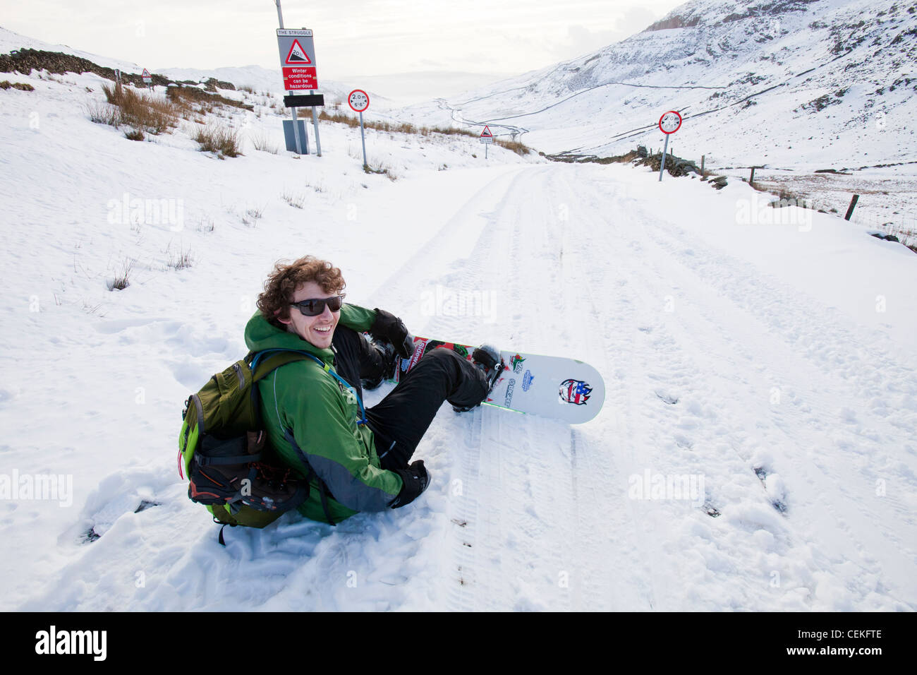 Un homme d'embarquement de la neige vers le bas depuis le sommet de la puce dans le Lake District, UK Banque D'Images