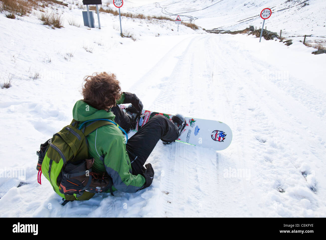Un homme d'embarquement de la neige vers le bas depuis le sommet de la puce dans le Lake District, UK Banque D'Images