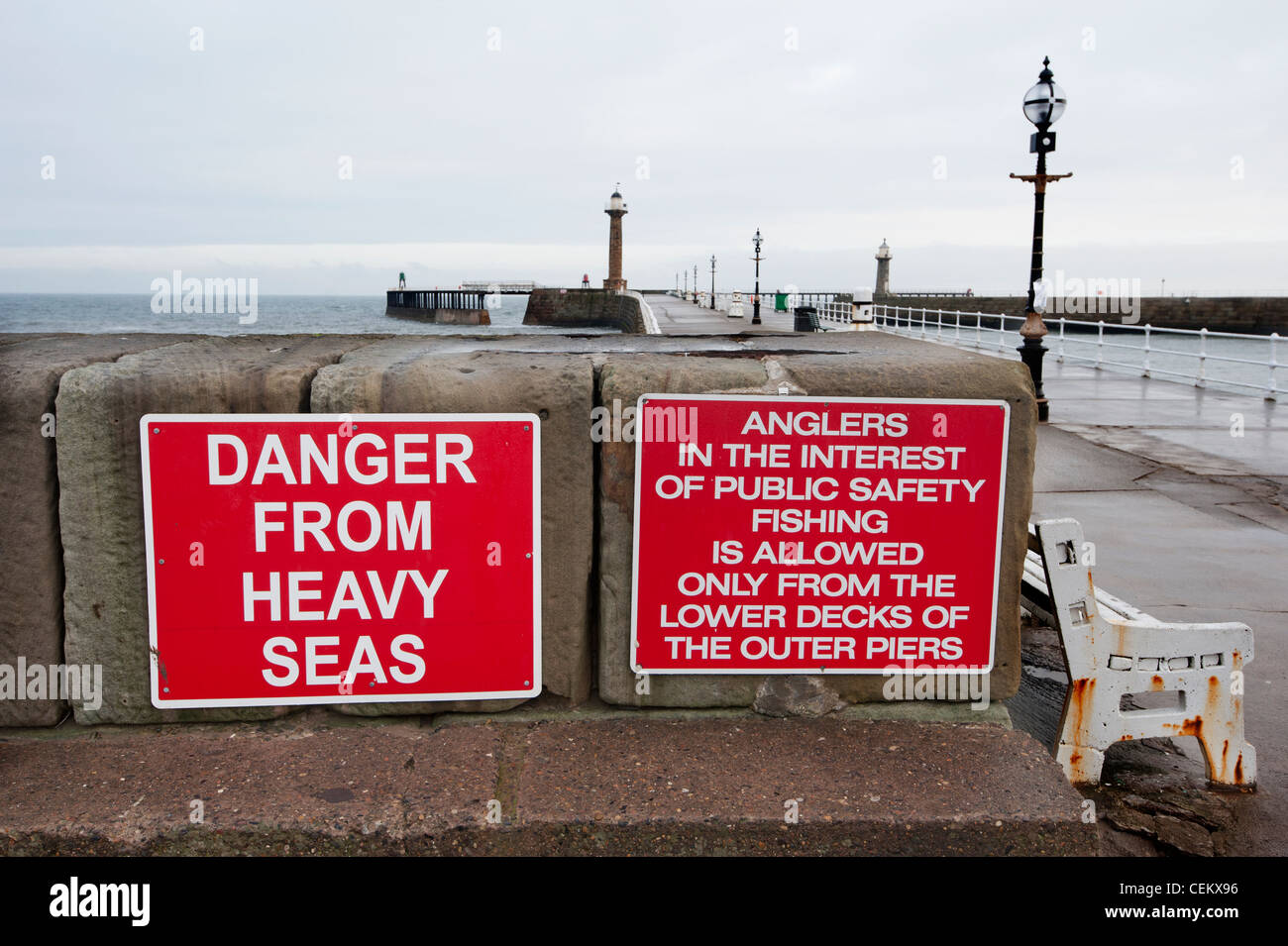 Fond rouge avec texte blanc Panneaux d'avertissement de sécurité publique à Whitby Harbour dans Yorkshire du Nord Banque D'Images