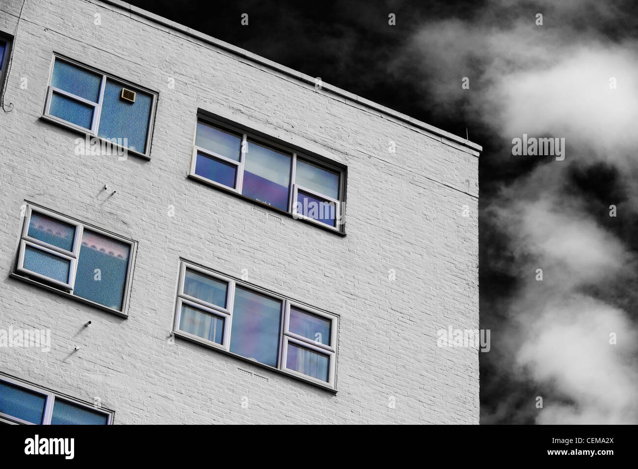 Coin et toit d'un bâtiment peint en blanc contre un ciel dramatique Banque D'Images