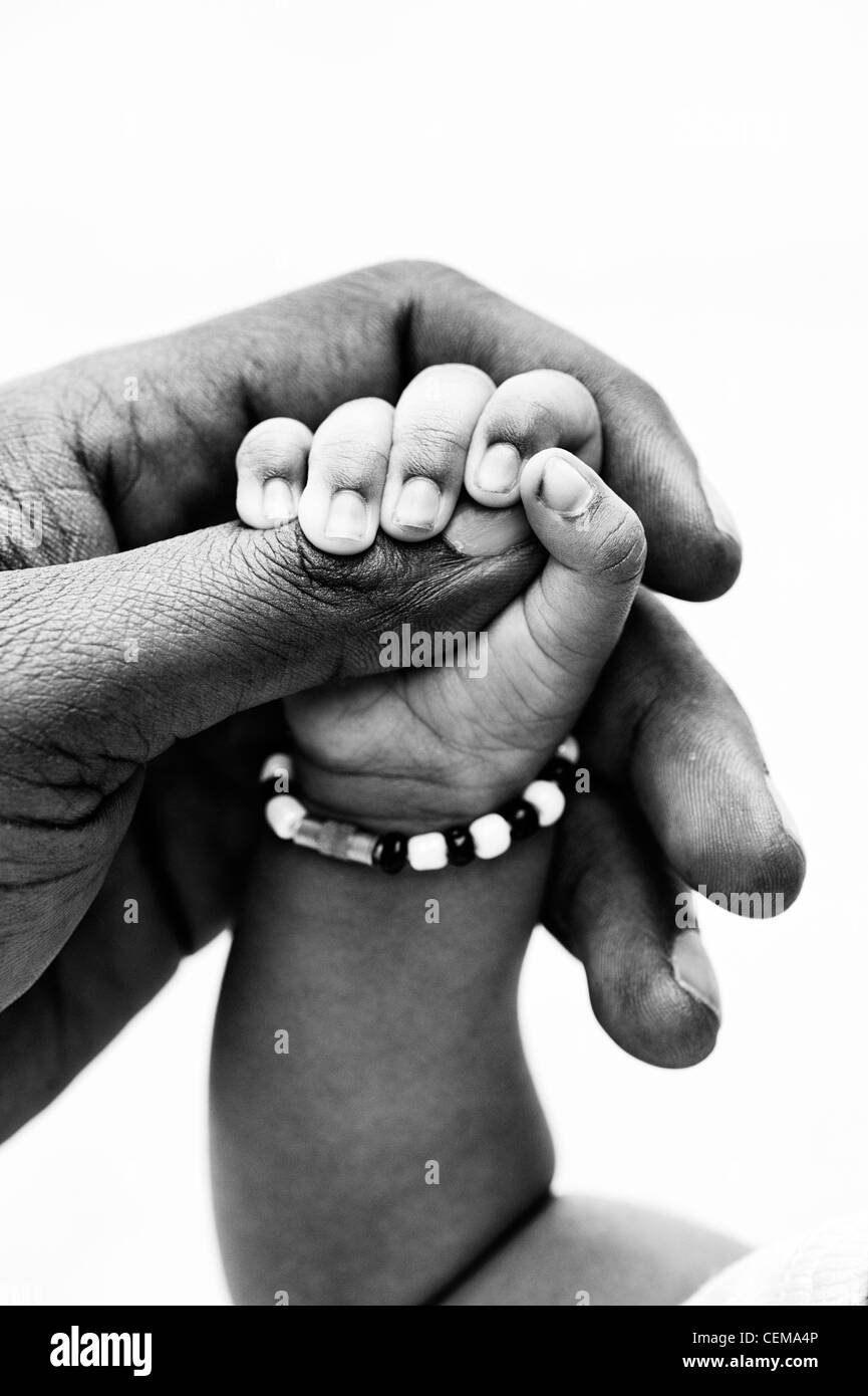 Indian mans main tenant son nouveau bébé part fond blanc. Monochrome. L'Andhra Pradesh, Inde Banque D'Images
