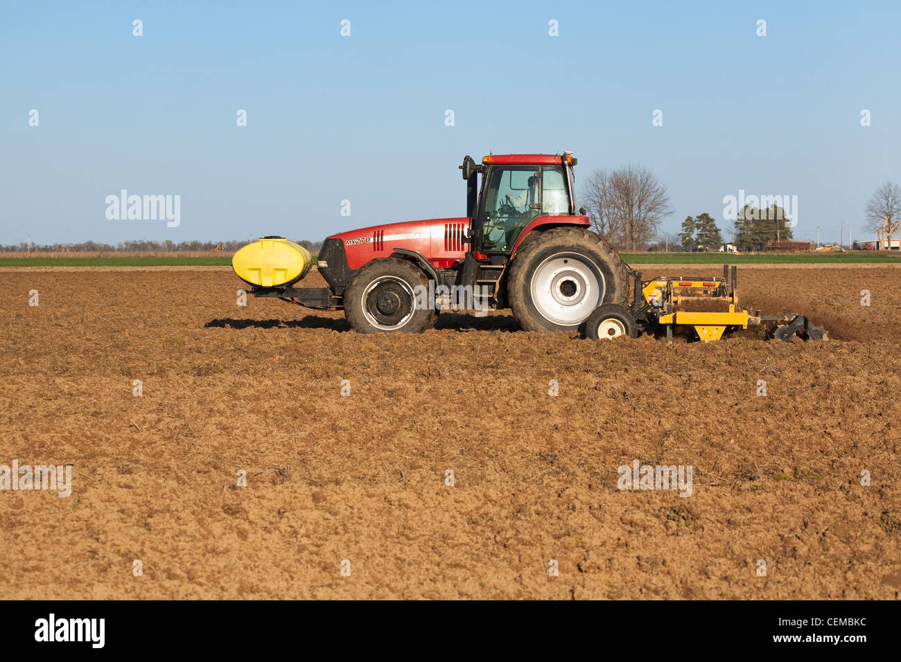 Tracteur Case IH un champ et la mise en œuvre de terminer la préparation du sol d'un champ à la fin du printemps pour la plantation de coton et de l'Arkansas. Banque D'Images