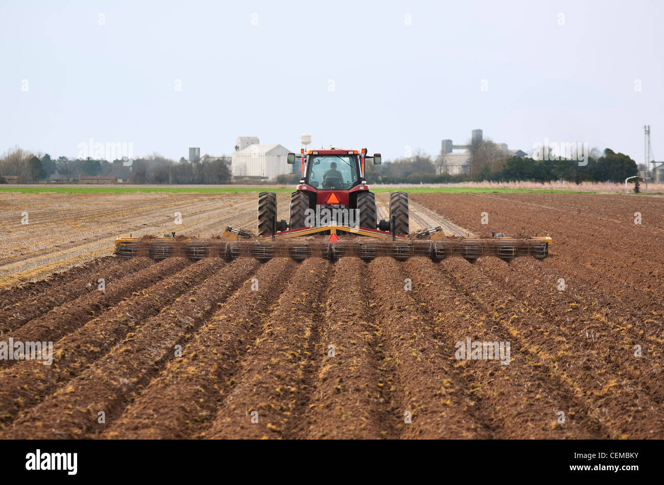 Tracteur Case IH un champ et la mise en œuvre de terminer la préparation du sol d'un champ à la fin du printemps pour la plantation de coton et de l'Arkansas. Banque D'Images