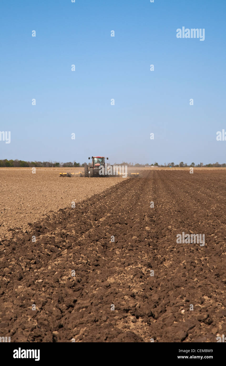 Tracteur Case IH un champ et mettre en œuvre une préparation du sol dans un champ à la fin du printemps pour les semis de maïs / New York, USA. Banque D'Images