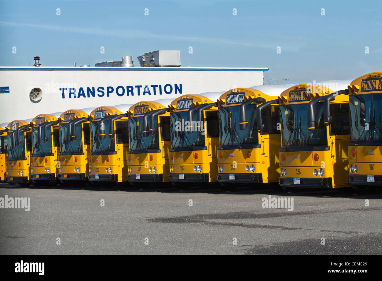 Une ligne d'autobus scolaires garés dans leur dépôt. Banque D'Images