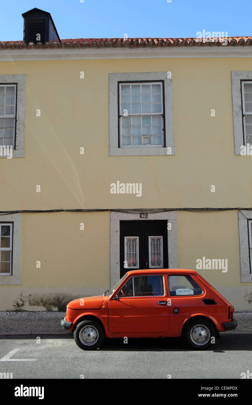 Fiat 600 classic orange petite voiture garée à l'extérieur de maison jaune, Lisbonne, Portugal, Europe Banque D'Images