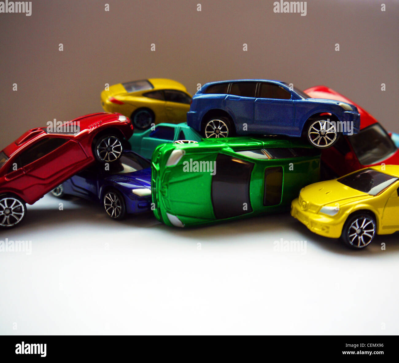 Une pile de voitures jouets colorés sur fond blanc Banque D'Images