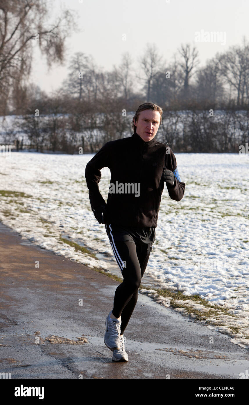 Portrait d'un homme sur un sentier de jogging tarmac en hiver, Hampstead Heath, London, England, UK Banque D'Images