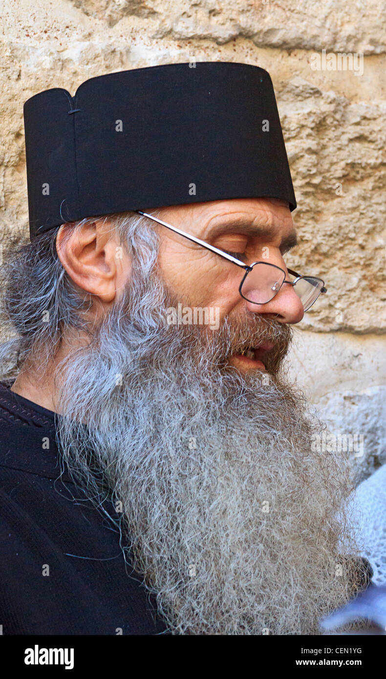 Prêtre grec orthodoxe conduit fidèles en prière dans l'église du Saint-Sépulcre dans la vieille ville de Jérusalem, Israël. Banque D'Images