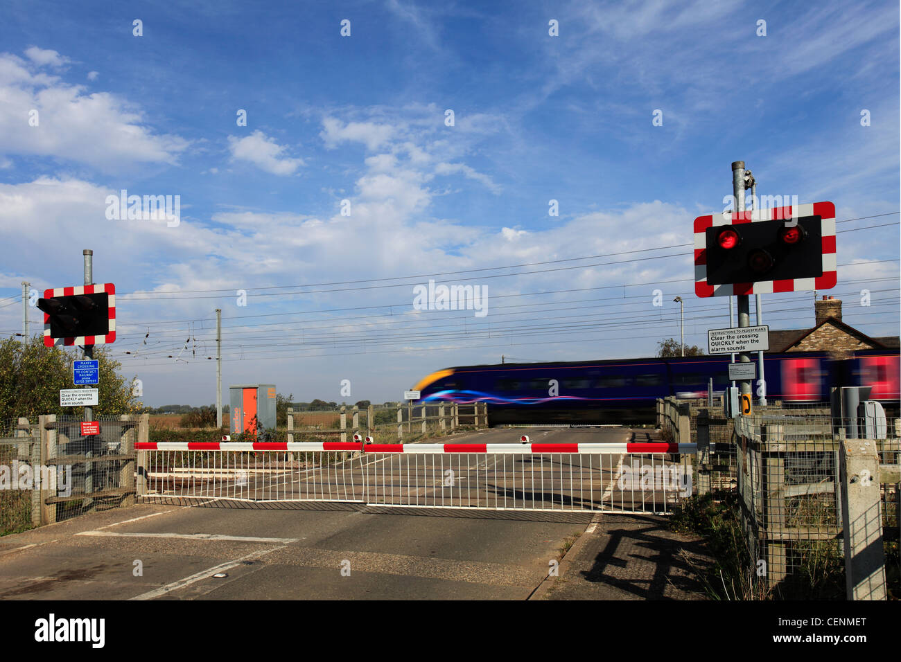 Excès de train à un passage à niveau sans pilote, East Coast Main Line Railway, Cambridgeshire, Angleterre, RU Banque D'Images