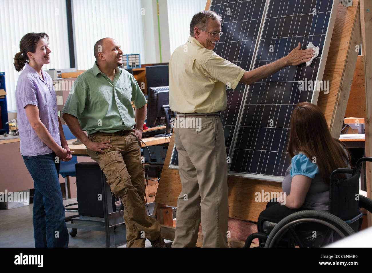 Les étudiants ingénieurs en regardant le professeur panneau photovoltaïque nettoyage pour démontrer l'amélioration de l'efficience Banque D'Images