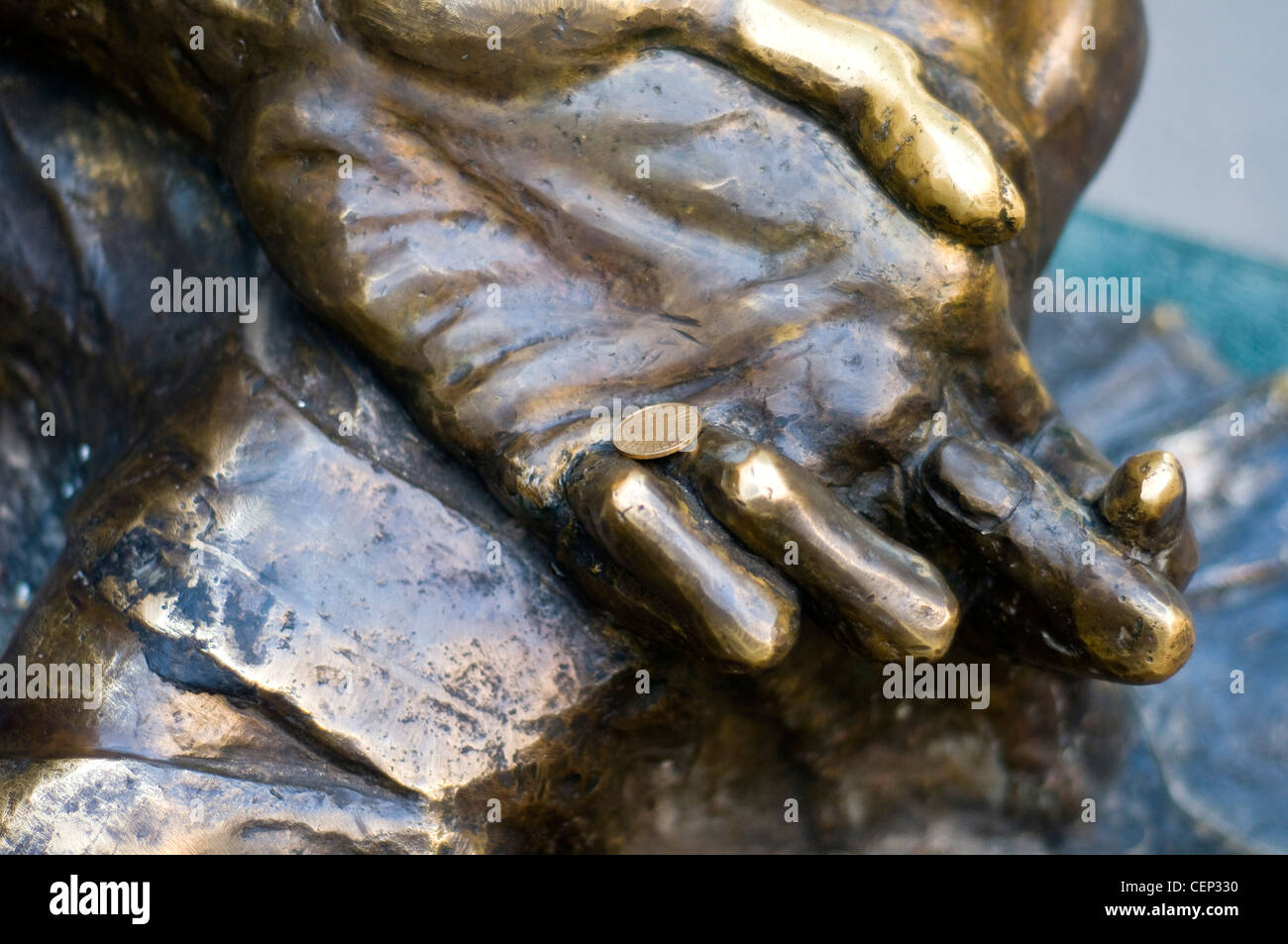 Sculpture en bronze de mains ouvertes tenant des pièces de monnaie comme oeuvre symbolique dans Skopje, Macédoine du Nord Banque D'Images