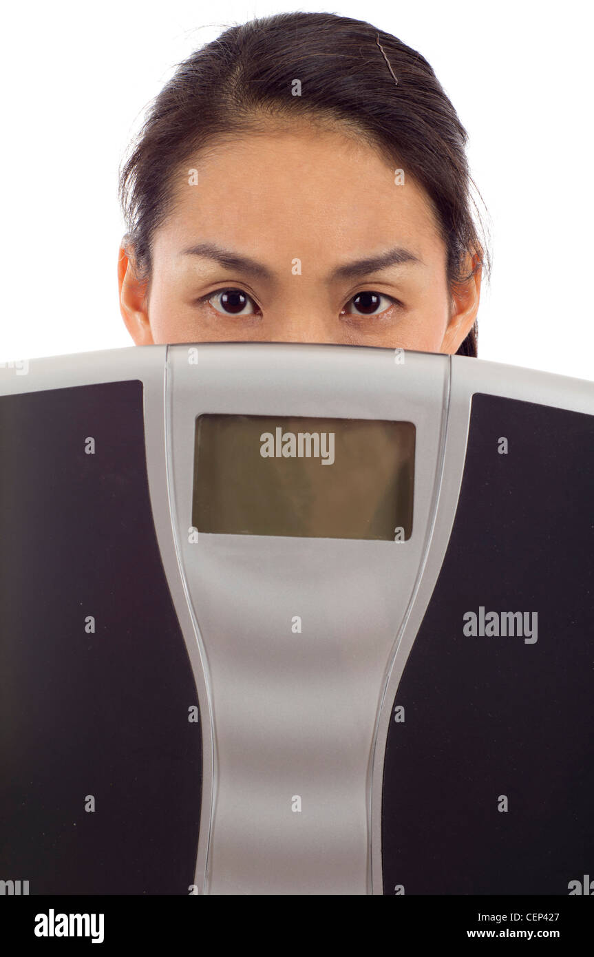 Gros plan du Asian woman holding a balance numérique isolé sur fond blanc Banque D'Images