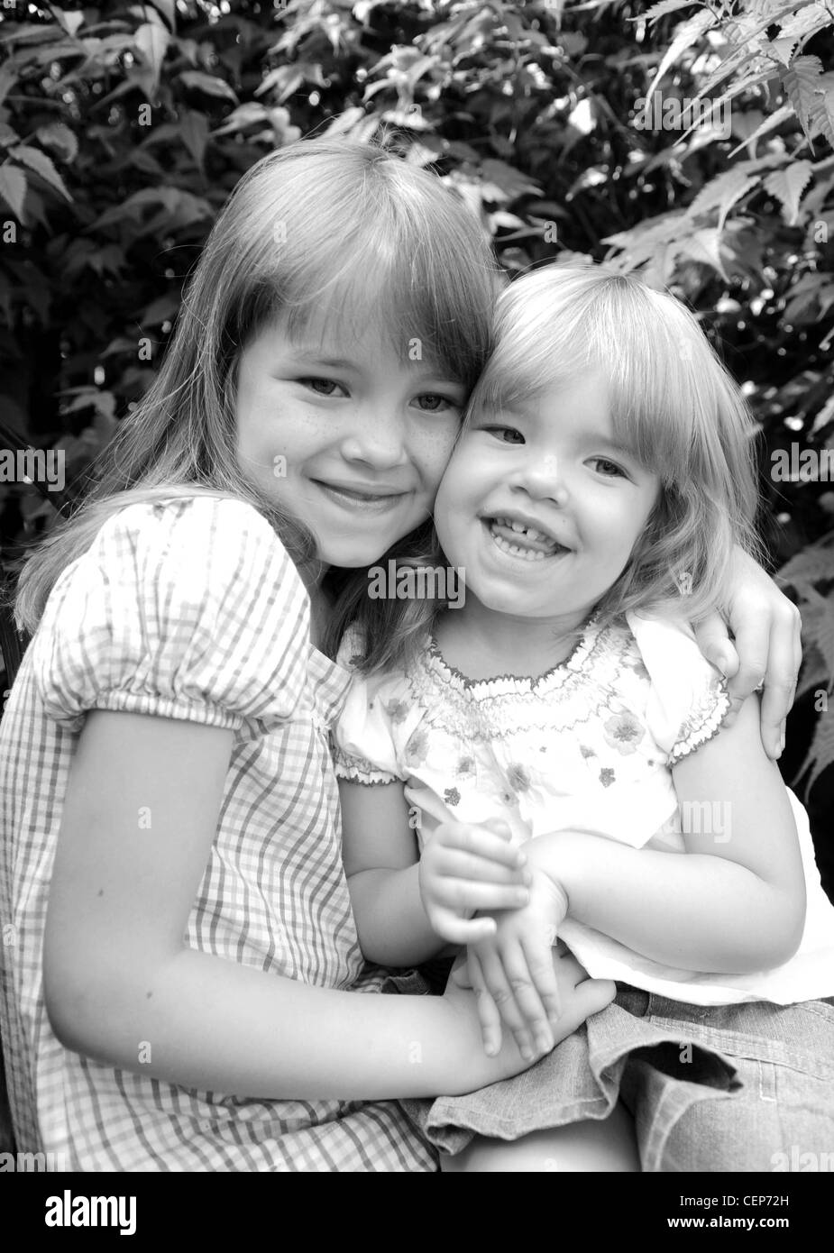 Les filles avec cheveux blonds frangé, portant des jeans et tops d'été coloré, souriant, à côté Banque D'Images