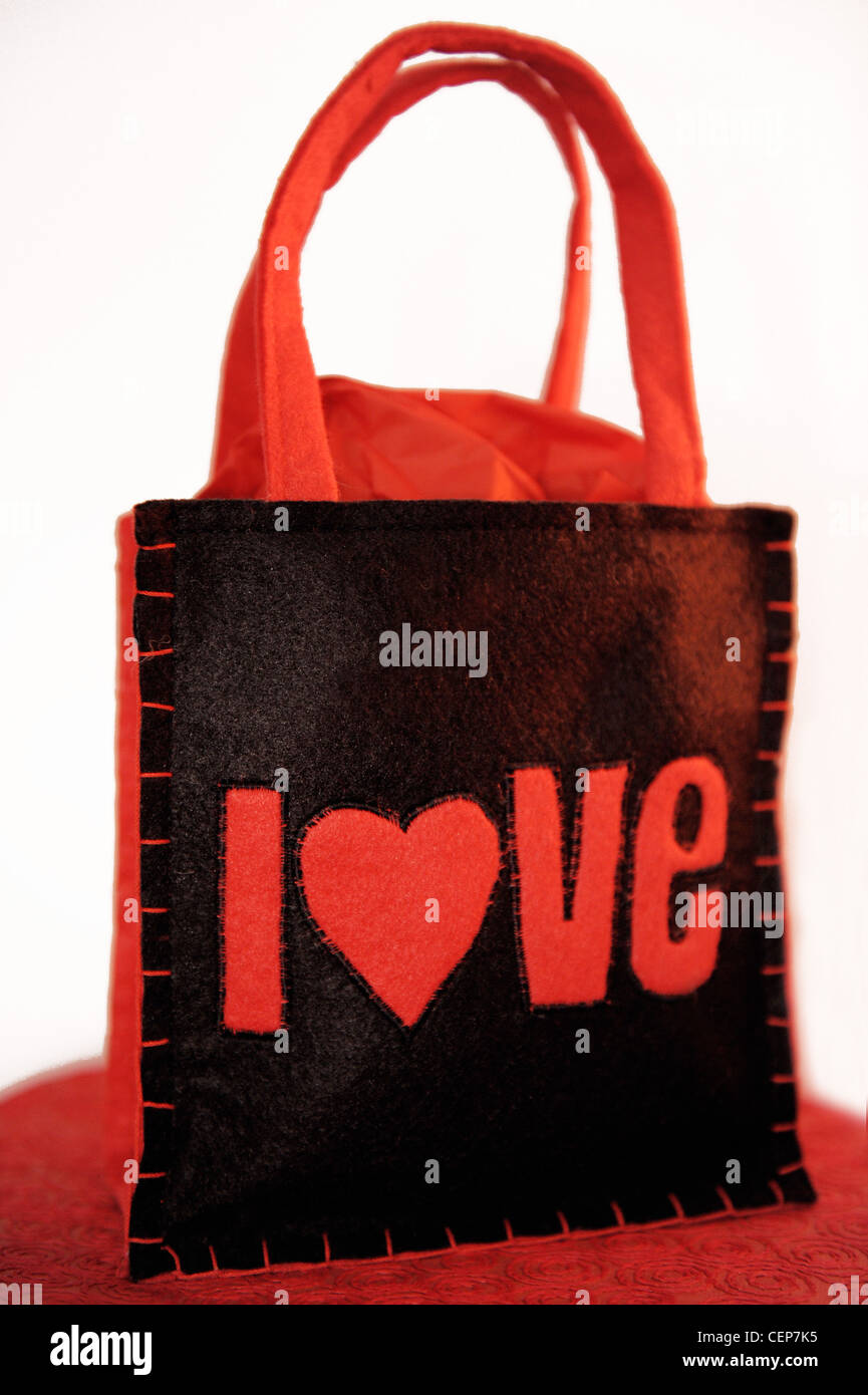Still Life image d'un sac à main feutre noir avec des poignées rouges et de l'amour appliqué Banque D'Images