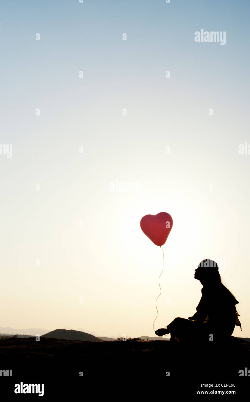 Indian woman holding a balloon. Silhouette Banque D'Images