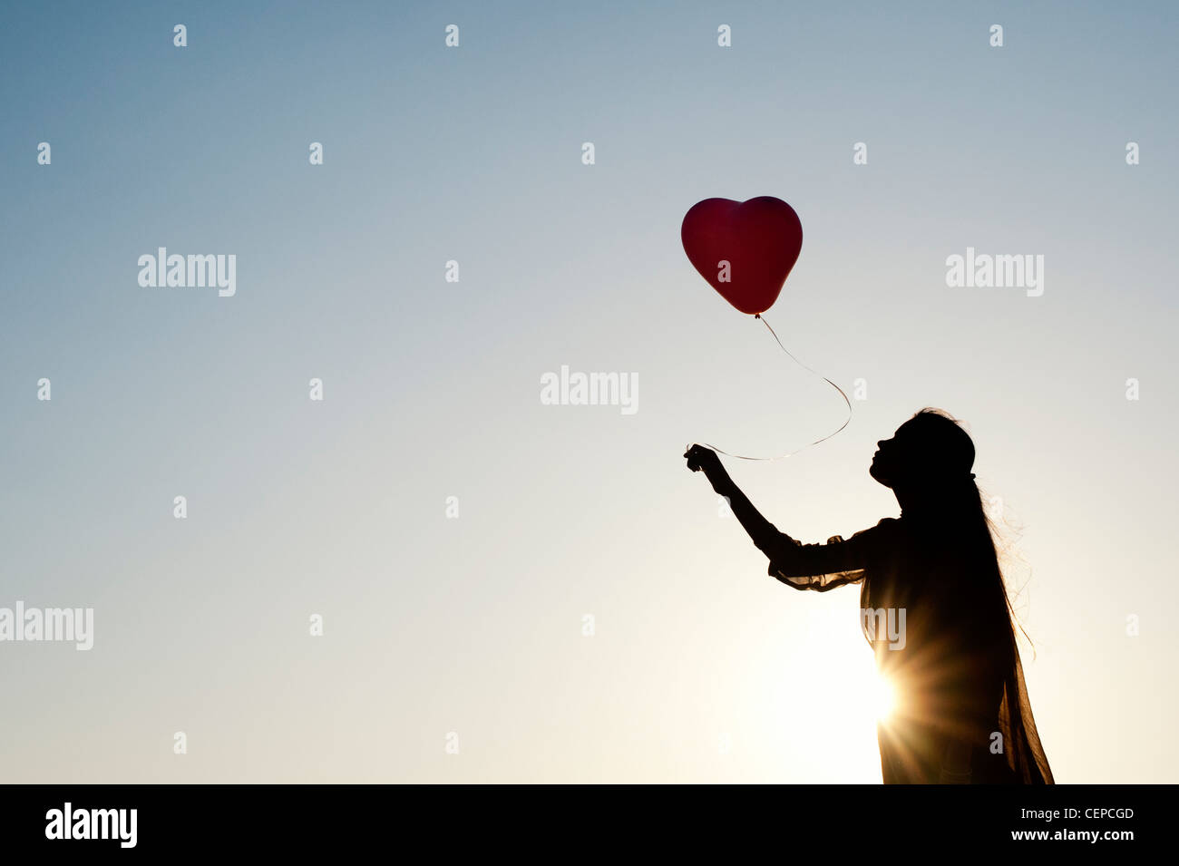 Indian woman holding a balloon. Silhouette Banque D'Images