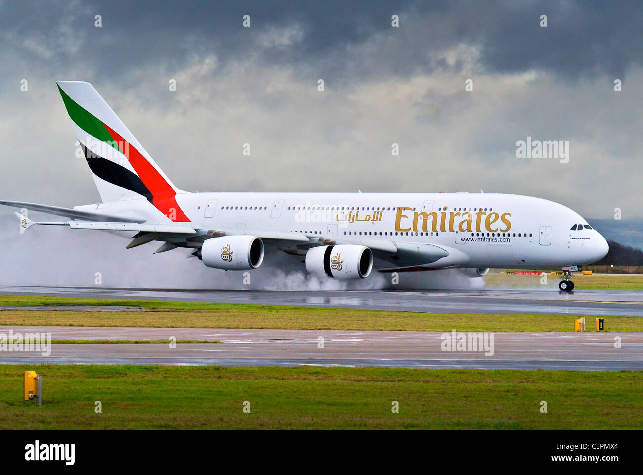 Airbus A380-800 Emirates spray crée un atterrissage sur une piste mouillée à l'aéroport de Manchester. Banque D'Images