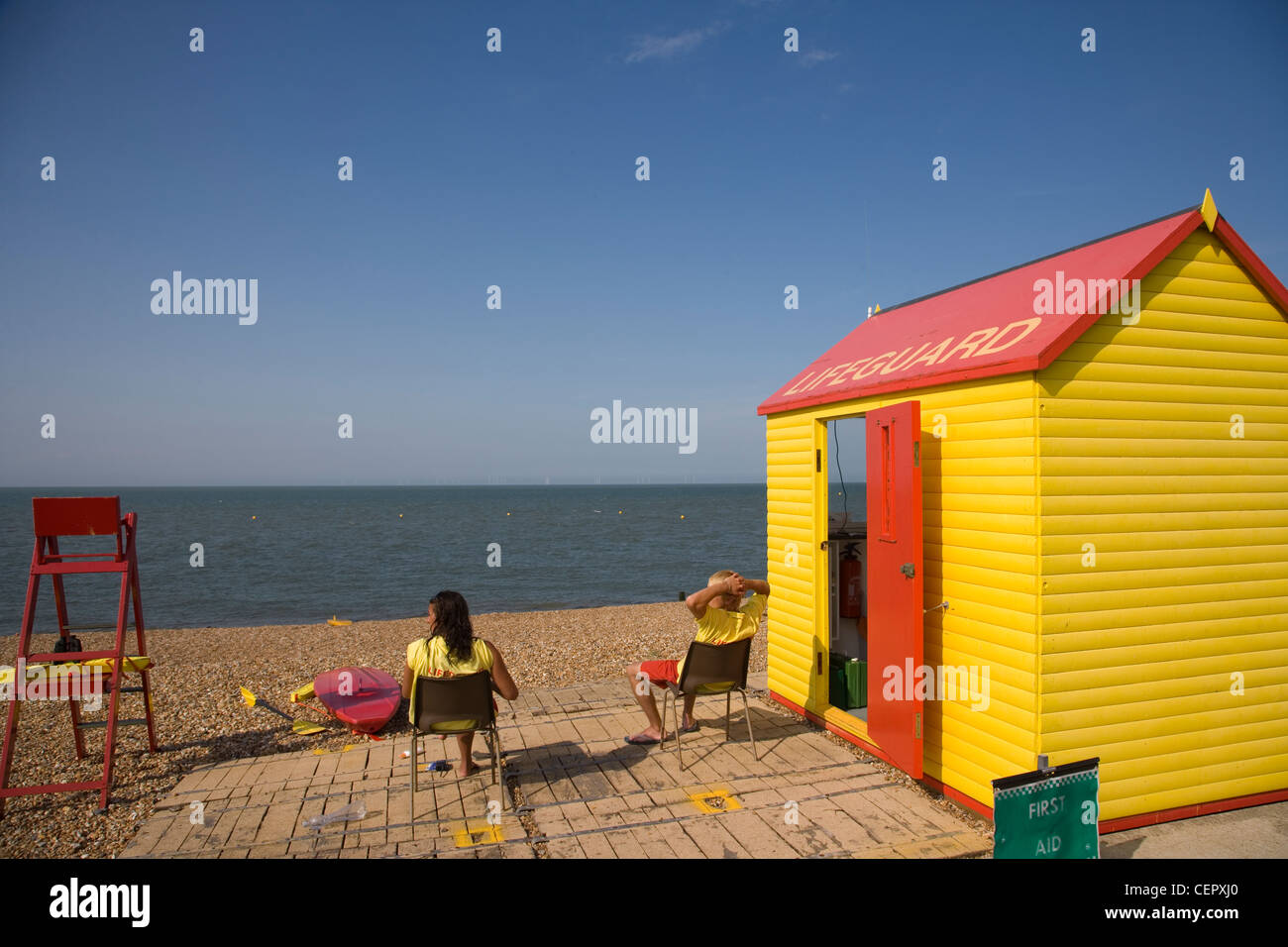 Deux maîtres nageurs assis sur le devoir à l'extérieur de leur cabane sur la plage à Whitstable. Banque D'Images