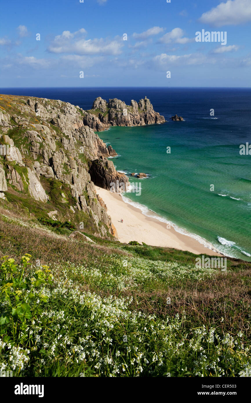Vue le long du promontoire rocheux vers Logan Rock de Treen falaises. La baie et la plage de Porthcurno entourés par le headla rock Logan Banque D'Images