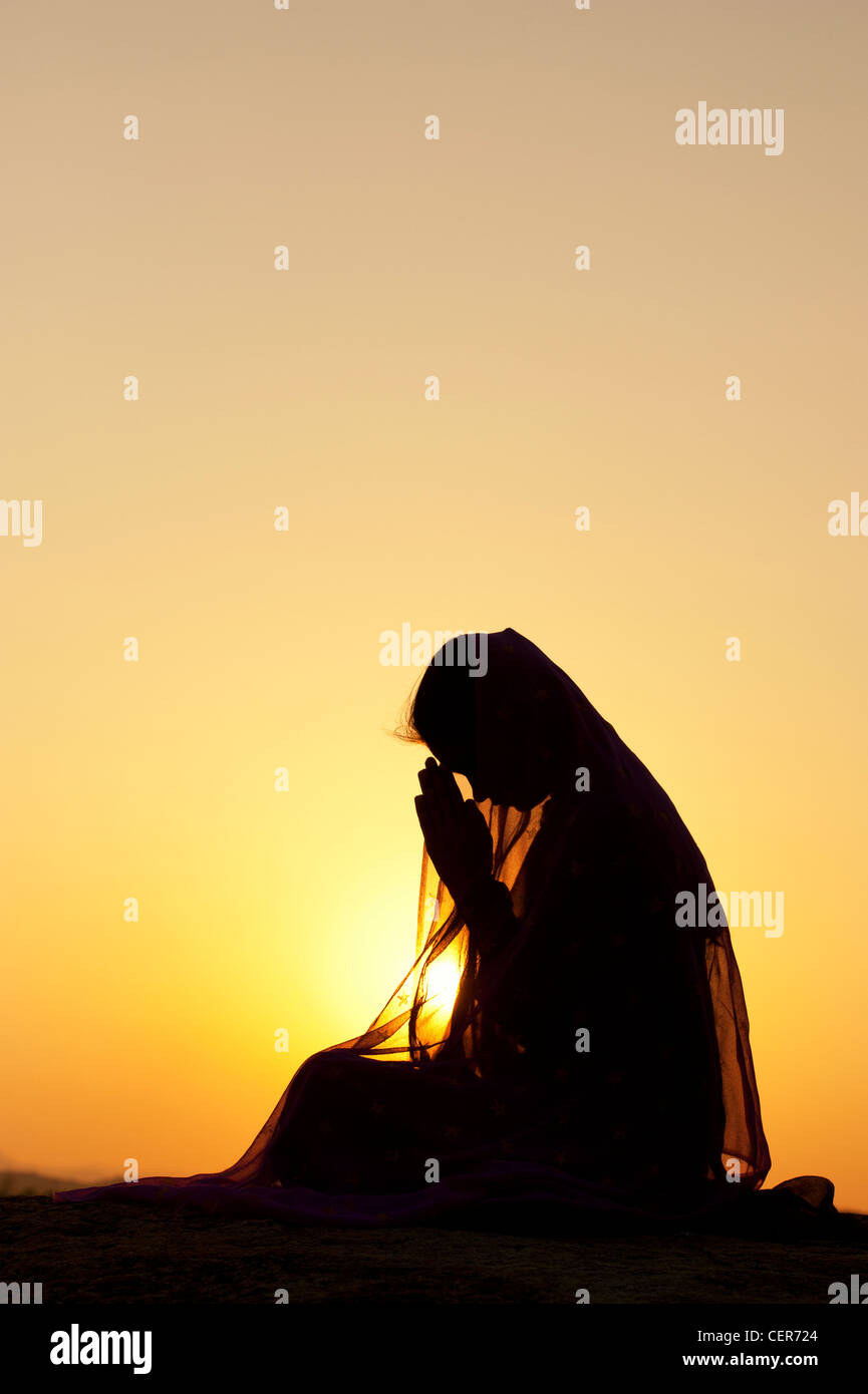 Indian woman praying at sunset couverts par une étoile voile. Silhouette. L'Inde Banque D'Images