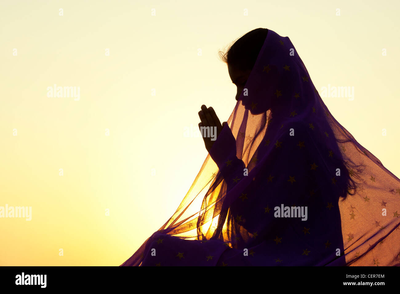 Indian woman praying at sunset couverts par une étoile voile. Silhouette. L'Inde Banque D'Images