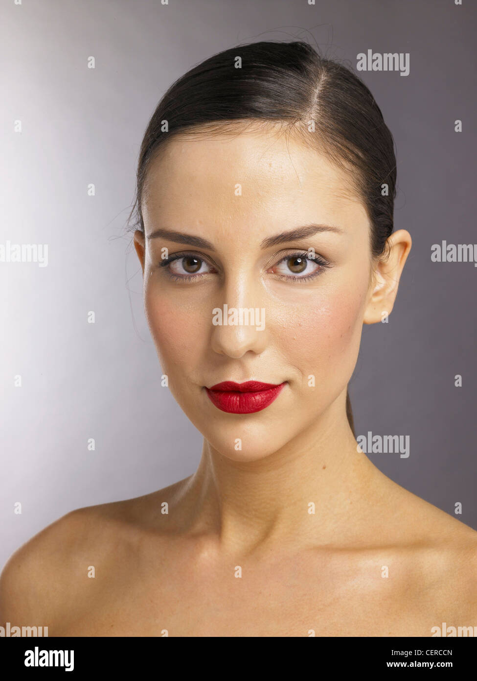 Femelle brune avec les cheveux en une queue de cheval avec la séparation, le côté rouge à lèvres rouge, à la recherche d'appareil photo Banque D'Images