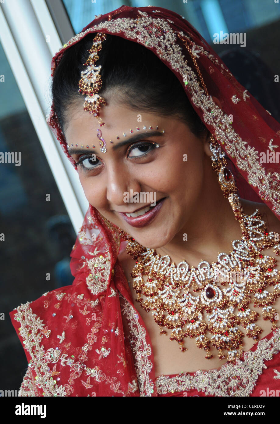 Jeune danseuse indienne en costume et bijoux exquis effectuant la danse de mariage avec ses yeux montrant des gestes de l'amour. Banque D'Images
