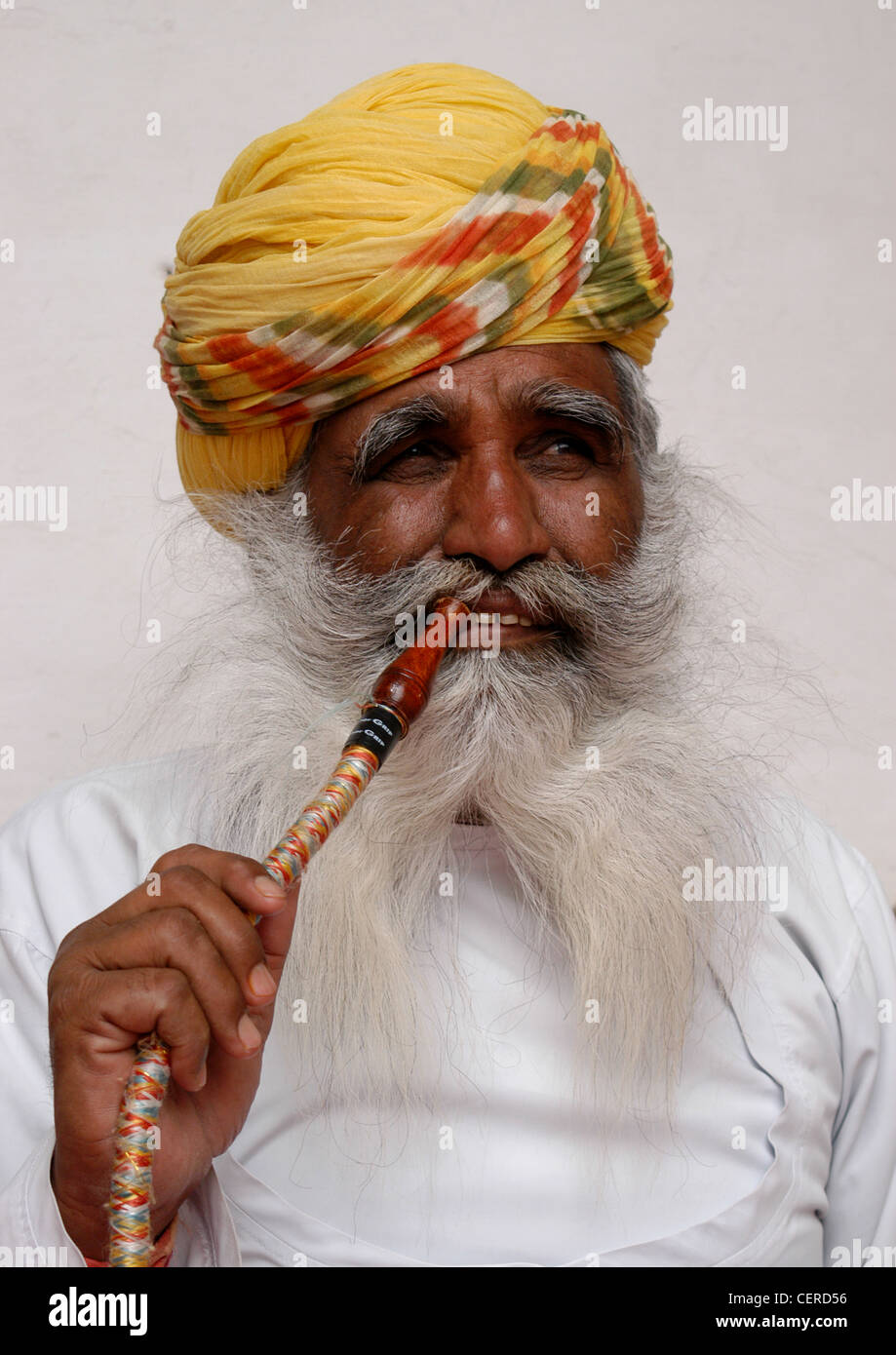 L'homme représentant de Rajput Royaume Rajasthani montrant méthode de fumeurs de tabac La fumée par filtrée tuyau narguilé pour la détente. Banque D'Images
