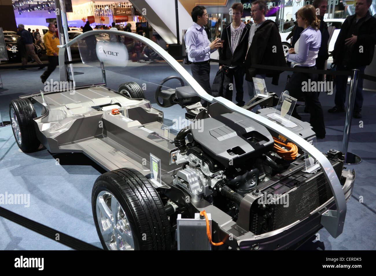 Coupe transversale d'une voiture hybride Chevrolet Volt avec une personne de ventes expliquez aux clients à l'arrière-plan. Banque D'Images