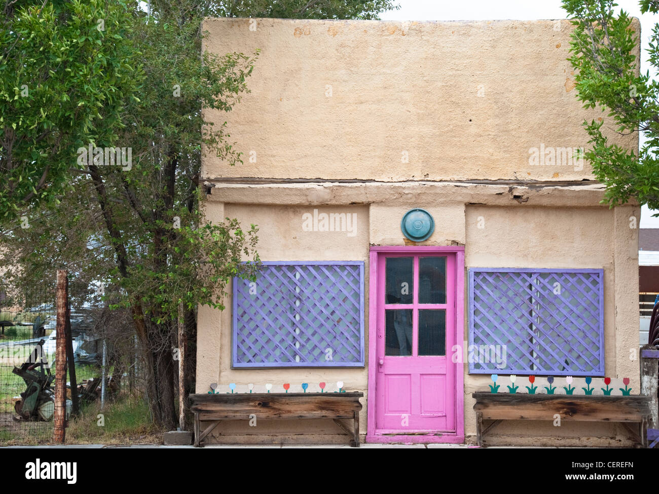 Une porte rose sur une maison d'adobe en stuc sur la rue principale à Fort Sumner, Nouveau Mexique. Banque D'Images