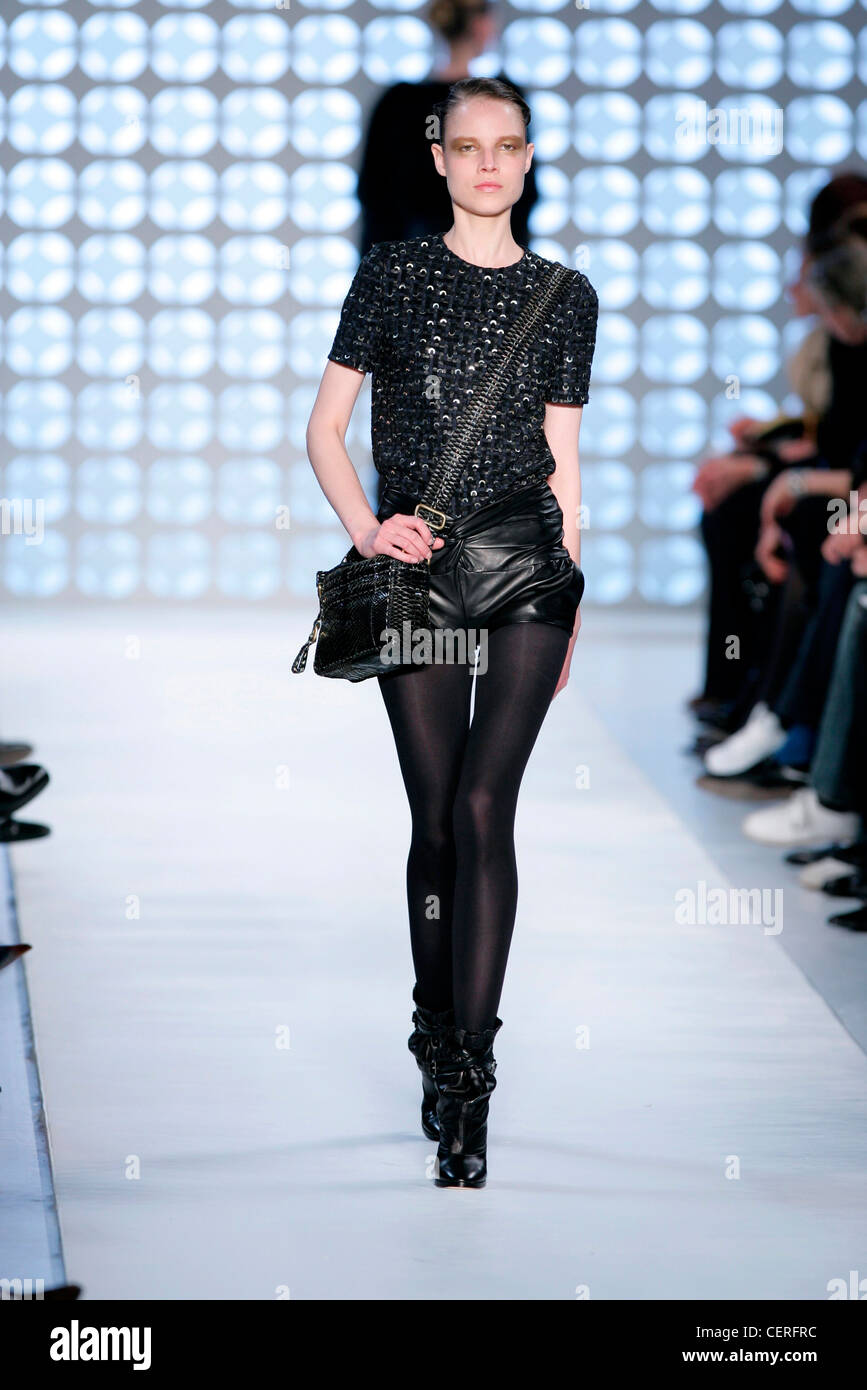 Model wearing, short en cuir noir texturé noir top col rond noir, collant  noir, bottes en cuir noir souple Photo Stock - Alamy