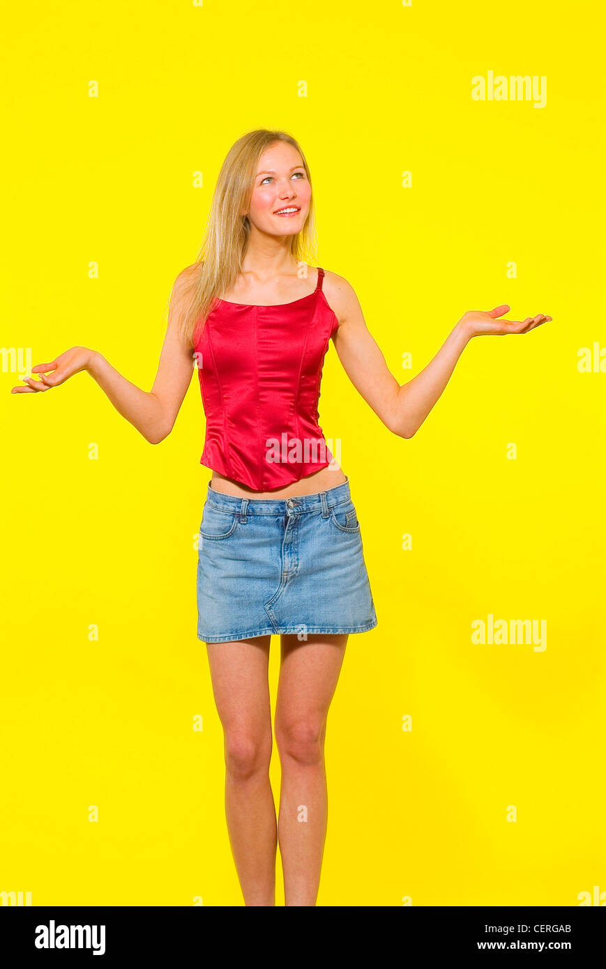 Femme, cheveux blonds, mini jupe en jean, style corset en satin rouge, haut  standing with arms up Aldo Truglio Photo Stock - Alamy