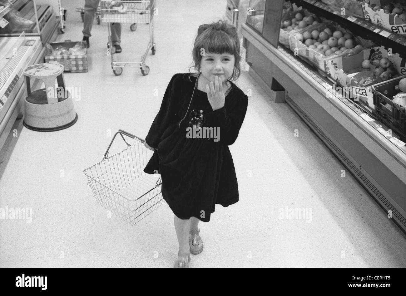 Enfant de sexe féminin dans le panier de transport allée de supermarché Banque D'Images