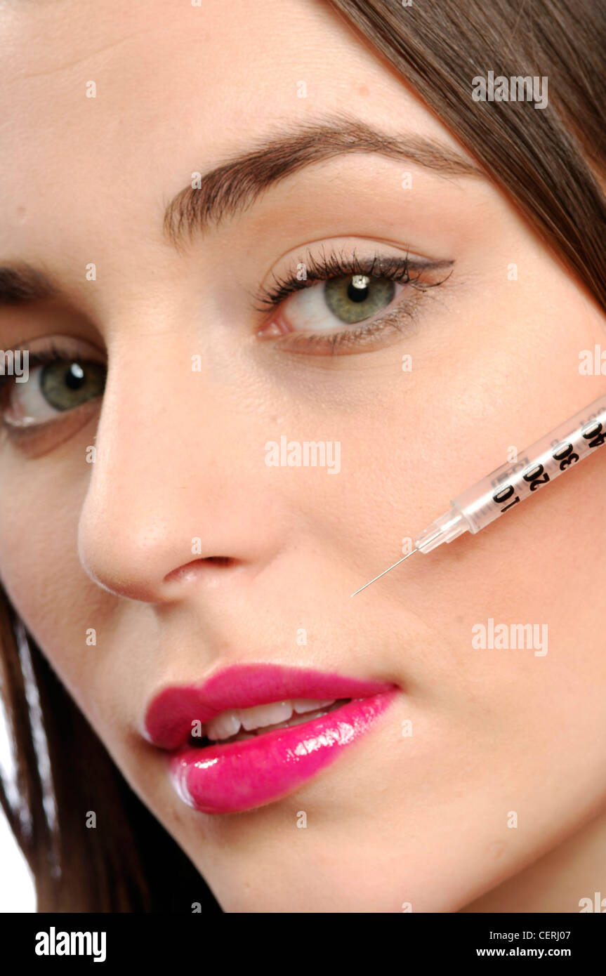 Close up de femmes avec des cheveux brune avec aiguille pointée sur la lèvre supérieure à la caméra à la bouche légèrement ouverte Banque D'Images