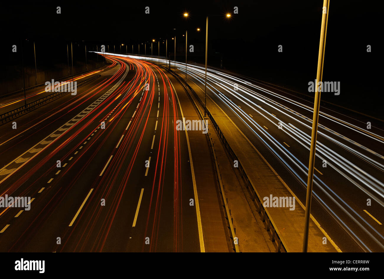 Vue de nuit d'un pont de lumière des sentiers de la circulation sur l'autoroute M25. Banque D'Images