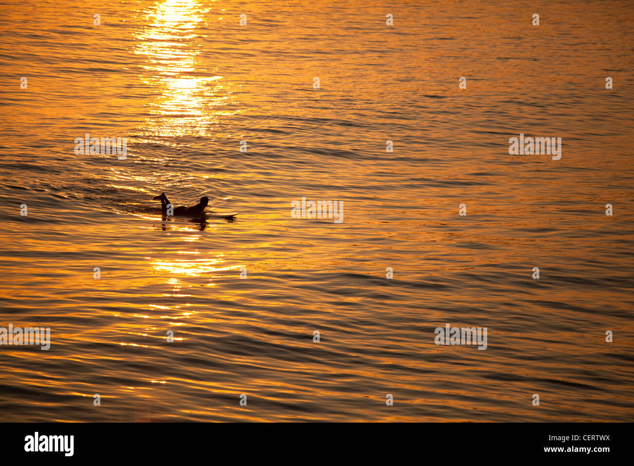 Lone, seul surfer au coucher et au lever du soleil Banque D'Images