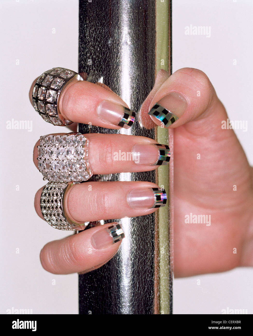 Femelle Avec Damier Noir Et Argent Nails Design Et Grandes Bagues Diamante Avec Main Autour De Poles D Argent Photo Stock Alamy