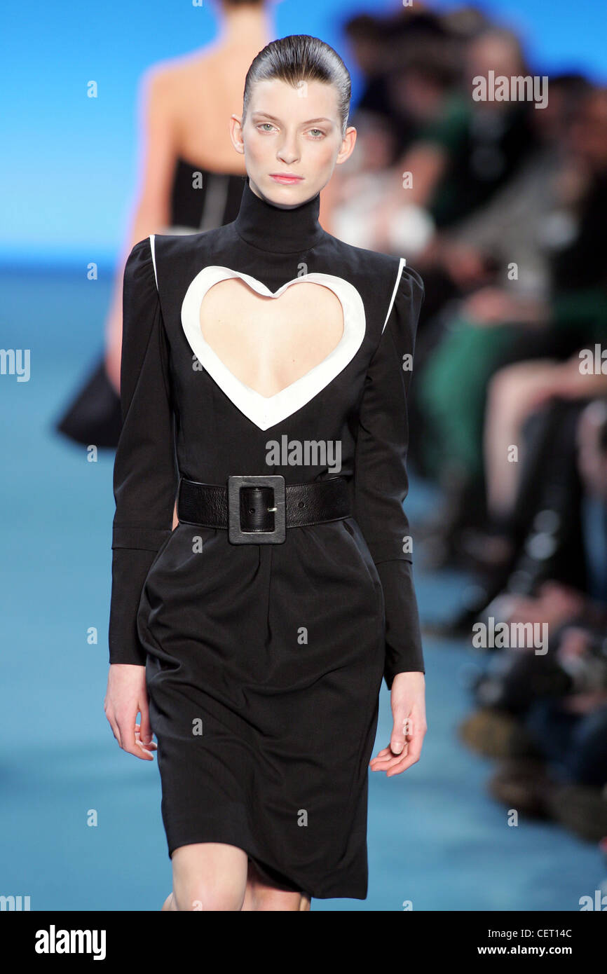 Haut noir longueur genou cou robe avec découpe centre forme de cœur, accessoirisée avec ceinture en cuir noir Banque D'Images