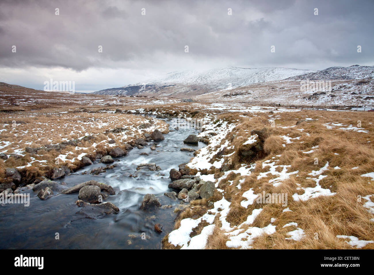 L'eau s'écoule vers le bas des montagnes sur les rochers dans le parc national de Snowdonia en hiver. Banque D'Images